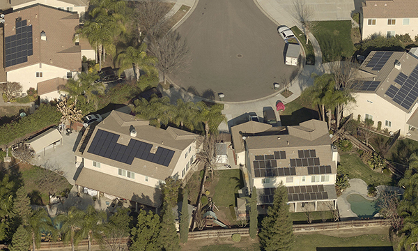 A cul-de-sac featuring homes with solar panels on the roofs.