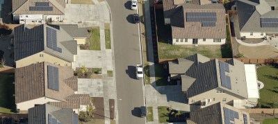 A residential neighborhood with solar panels on the roofs of each home.