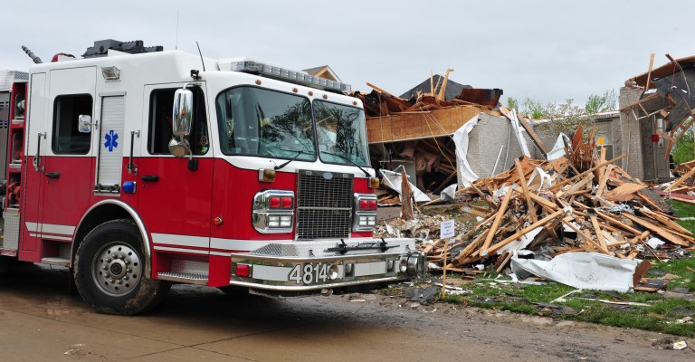 Fire truck parked outside wrecked building