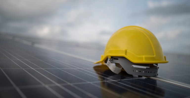 Yellow safety helmet on solar cell panel