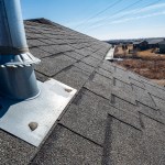 Vent on a shingle roof with silicon caulking and flashing for a water tight seal