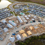 Aerial view of a residential construction site with partially built houses in various stages of development.