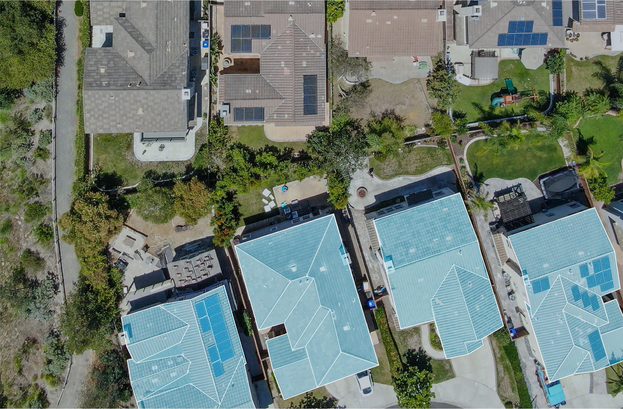 Aerial image of roofs of single family homes on a sunny day.
