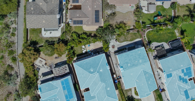 Aerial image of roofs of single family homes on a sunny day.