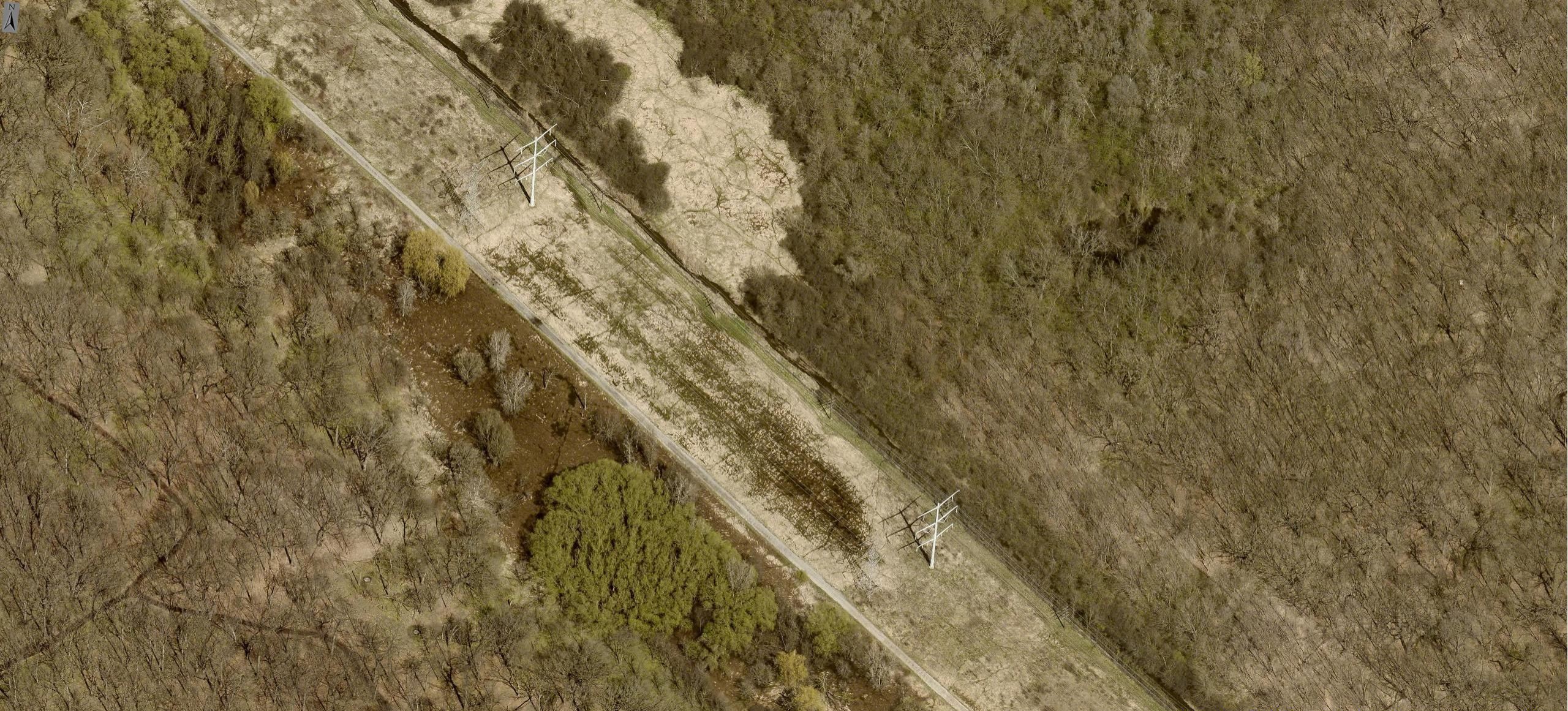 Aerial capture of a power line in a rural field.