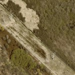Aerial capture of a power line in a rural field.