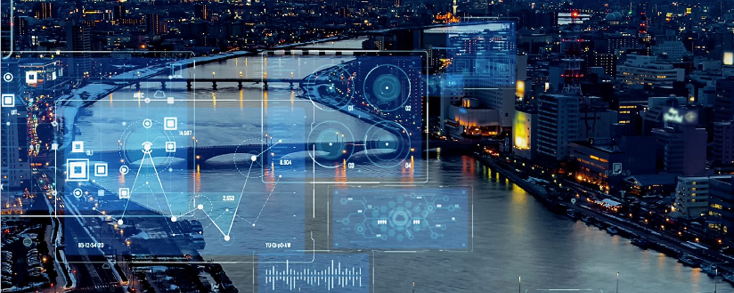 Aerial view of a city at dusk with a river winding through illuminated buildings and bridges, mountains silhouetted in the background. Transparent futuristic data interfaces—charts, graphs, maps, and circular HUD elements—are overlaid across the skyline, suggesting geospatial intelligence and smart city technology.